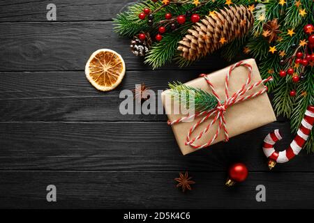 Vintage gift with christmas decorations on black wooden background Stock Photo