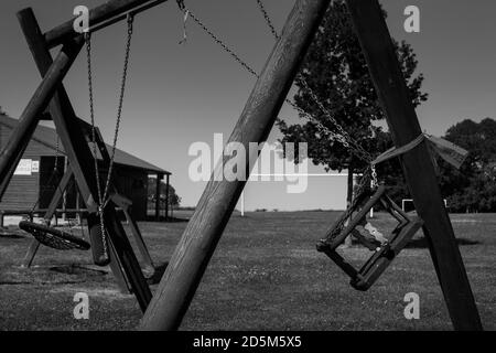 Tied up swing set in park during full lockdown in Hampshire, England. Pandemic prevention restricted lockdown Covid-19. Stock Photo