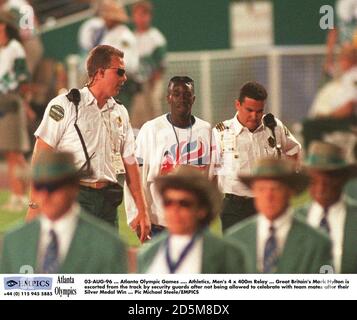 03-AUG-96 ... Atlanta Olympic Games .... Athletics, Men's 4 x 400m Relay ... Great Britain's Mark Hylton is escorted from the track by security guards after not being allowed to celebrate with team mates after their Silver Medal Win Stock Photo