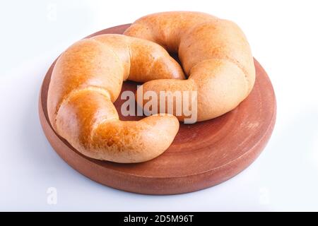 two croissants on a wooden cutting board isolated on white background. closeup. top view. Stock Photo