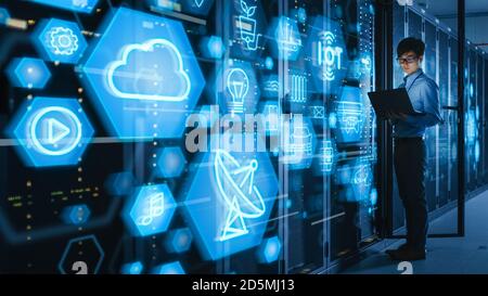 Shot of a Asian IT Engineer Using Laptop in a Data Center Server Room. Futuristic Concept with Different Computer Illustrative Icons and Symbols in Stock Photo