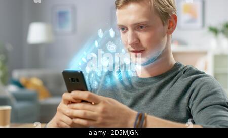 Visual Effect of Connecting and Surfing the Web with Illustrative Icons and Symbols. Handsome Young Man Uses Smartphone in His Living Room. Browsing Stock Photo