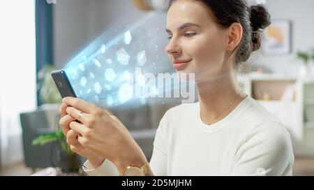Visual Effect of Connecting and Surfing the Web with Illustrative Icons and Symbols. Handsome Young Woman Uses Smartphone in Her Living Room. Browsing Stock Photo