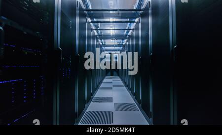 Data Center With Between Two Rows of Fully Operational Server Racks. Modern Telecommunications, Cloud Computing, Artificial Intelligence, Database Stock Photo