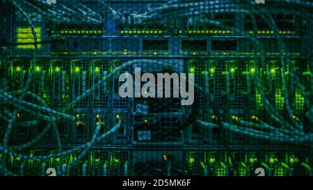 Close-up Shot In Data Center: Insides of the Working Server Rack Showing Hardware Equipment, Fiber Optic Broadband Cables, Blinking LED Lights. Stock Photo