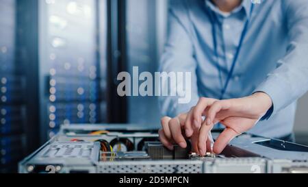 Close-up Shot in Modern Data Center: IT Engineer Installs New Hardware for Server Rack. IT Specialist Doing Maintenance, Running Diagnostics and Stock Photo