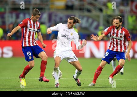 Real Madrid's Gareth Bale (centre) and Atletico Madrid's Gabi (left) battle for the ball  Stock Photo