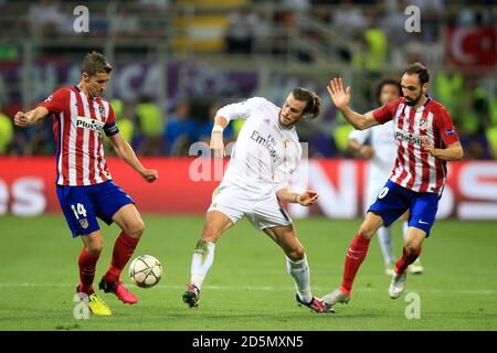 Real Madrid's Gareth Bale (centre) and Atletico Madrid's Gabi (left) battle for the ball  Stock Photo