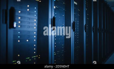 Shot of Dark Modern Data Center With Row of Fully Operational Server Racks. Modern Hi-Tech Concept for Cloud Computing, Artificial Intelligence Stock Photo