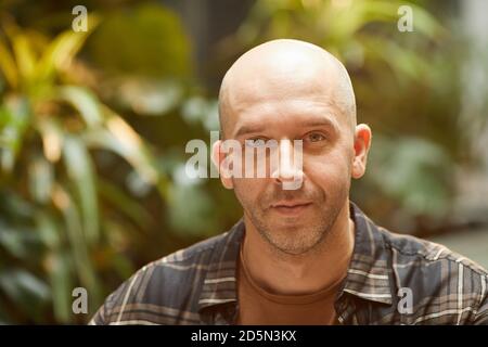Portrait of mature balded man in shirt looking at camera Stock Photo