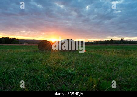 Beautiful sunset on the field in Őrség Hungary with sunbeams and bales Stock Photo