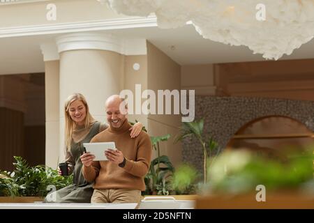 Young happy couple watching something on digital tablet together and smiling Stock Photo