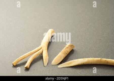 Close up of  horseradish roots on a grey stone table Stock Photo