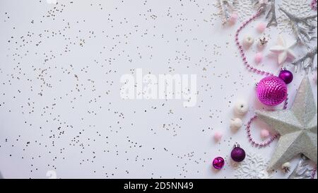 Christmas and New Year white stars,snowflakes and purple Christmas balls and decorations among sparkles on white background,top view,flat lay,copy spa Stock Photo