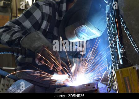 Welder in protective clothing at the workplace in an industrial company in steel construction Stock Photo
