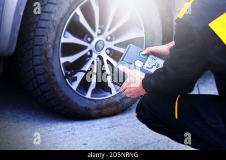 Close-up of manometer and man hands checking tire pressure with gauge. High quality photo Stock Photo