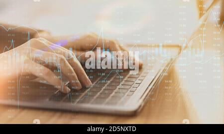Stock market trading graph chart layered over female hands working on laptop Stock Photo