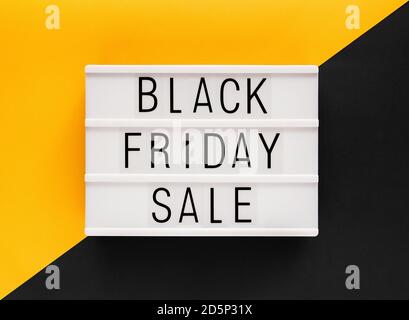 Stock photo of Black Friday sale text on a white light box and a bicolor background Stock Photo