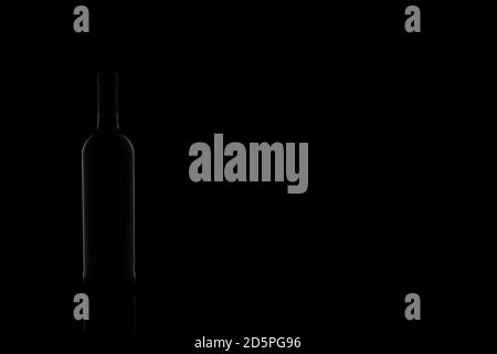 Wine bottle silhouette isolated on dark background. Studio photography. Stock Photo