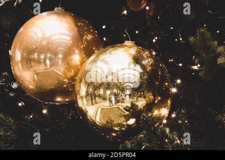 Golden baubles on christmas tree branch close up. Balls hanging on pine branches. Christmas background. Festive decoration. Merry Christmas and Happy Stock Photo