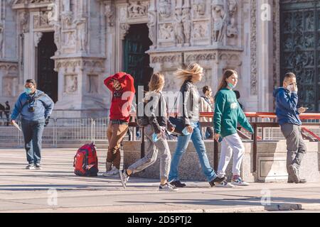 People wear protective masks prevent coronavirus, covid 19 during virus outbreak. Young people walking in center of Milan. Milan, Italy - 27.09.2020 Stock Photo