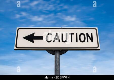 Caution road sign, arrow on blue sky background. One way blank road sign with copy space. Arrow on a pole pointing in one direction. Stock Photo