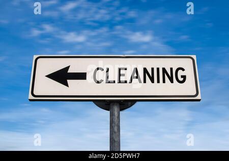 Cleaning road sign, arrow on blue sky background. One way blank road sign with copy space. Arrow on a pole pointing in one direction. Stock Photo