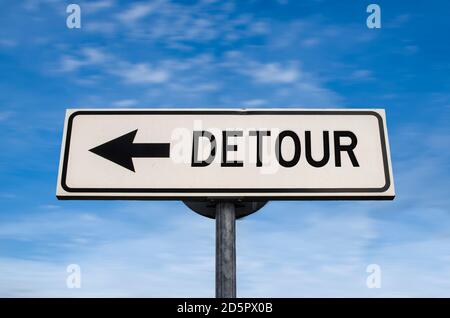 Detour road sign, arrow on blue sky background. One way blank road sign with copy space. Arrow on a pole pointing in one direction. Stock Photo