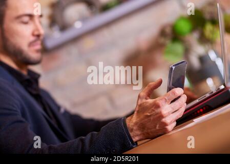 Closeup view of a businessman while using a smartphone in office environment. Stock Photo