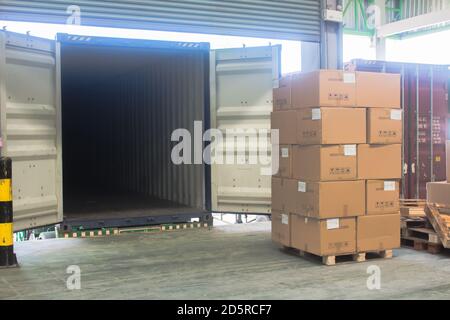 loading shipment carton boxes and goods on wooden pallet at loading dock from container Stock Photo