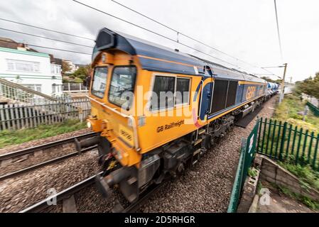 GB Railfreight Class 66 locomotive hauled leaf clearing freight train spraying the rails clean for improved traction. 3S70 Rail Head Treatment Train Stock Photo
