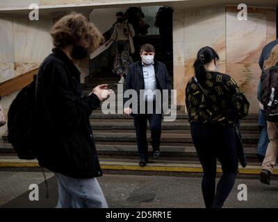 Moscow. Russia. October 5, 2020 People passengers with protective masks on their faces inside the metro station descend the stairs. Preventive Stock Photo