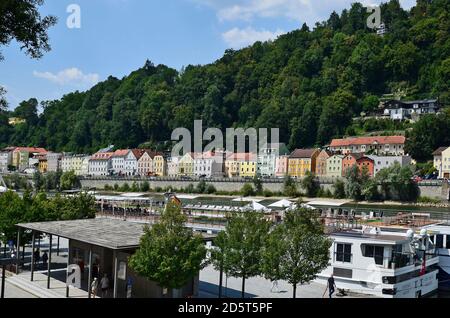 Passau, Germany - July 17, 2018: Unidentified people on perth for ships and buildings along Danube River in the city of Passau in Bavaria near the bor Stock Photo