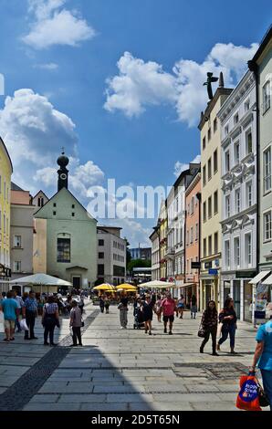 Passau, Germany - July 17, 2018: unknown people in Ludwigstrasse in the old town with different shops and Marist monastery with a distinctive onion do Stock Photo