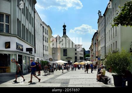 Passau, Germany - July 17, 2018: unknown people in Ludwigstrasse in the old town with different shops and Marist monastery with a distinctive onion do Stock Photo