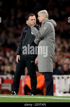 Arsenal manager Arsene Wenger (right) speaks with the fourth official Stuart Atwell (left) Stock Photo