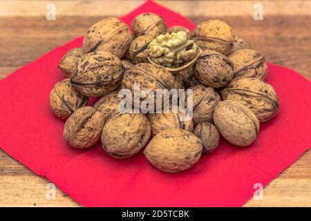 Closeup of big shelled walnuts pile. Walnut kernels and whole walnuts top view. Fresh raw walnuts full of healthy fats, fiber, vitamins and minerals.E Stock Photo