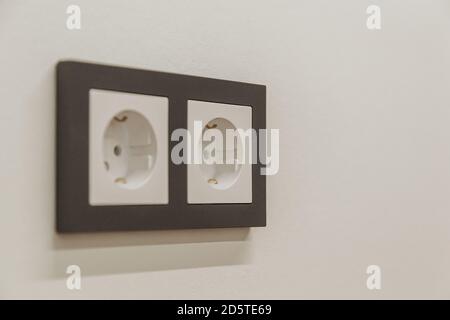 gray electrical outlet on white wall in room Stock Photo