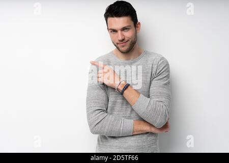 Happy smiling young man presenting and showing your text or product isolated on white background. Stock Photo