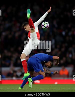 Arsenal's Gabriel Paulista battles for possession of the ball in the air with Leicester City's Leonardo Ulloa (right) Stock Photo