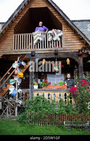 BREB, ROMANIA - 11 OCTOBER 2020: Two elderly women standing on the porch of a traditional wooden house in Maramures. Stock Photo