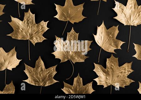 Autumn composition. Pattern made of autumn golden marple leaves on black background. Flat lay, top view, copy space Stock Photo