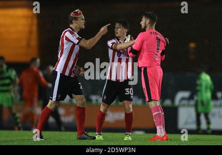 Tempers flare between Lincoln City's Sean Raggett (left) and Forest Green Rovers goalkeeper Bradley Collins after the final whistle Stock Photo