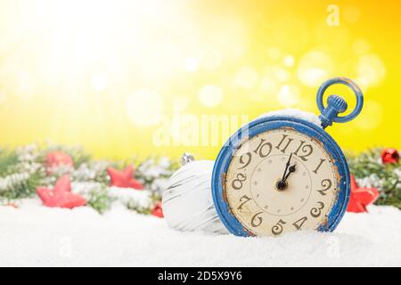 Christmas greeting card with alarm clock and decor in snow over blurred bokeh background and copy space for your xmas greetings Stock Photo