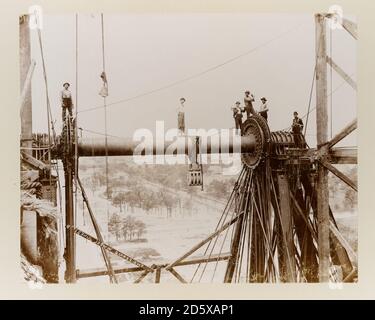 View of workers standing atop the Ferris wheel axle during its dismantling after the World's Columbian Exposition, Chicago, Illinois, June 21, 1894. Stock Photo