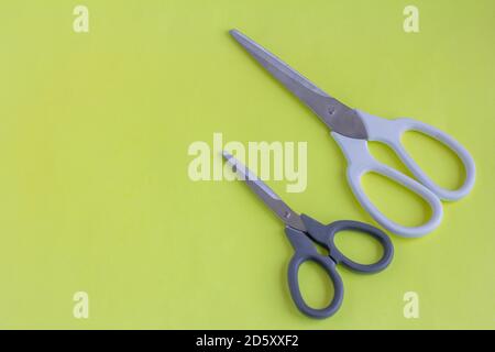 Scissors, big scissors and small scissors on a yellow background. White and black scissors with a copy of the space. Stock Photo