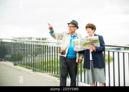 Senior couple with map standing on a bridge Stock Photo
