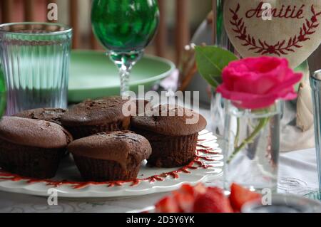 some chocolate muffins close up on a table ready from a brunch outdoor in the garden with friends. Life at home. Stock Photo