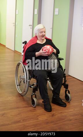 Age demented senior woman bowling with foam ball in a nursing home Stock Photo