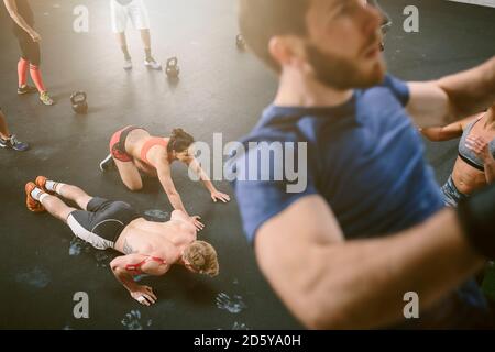 People in gym doing push ups and chin ups Stock Photo